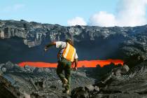 FILE--Ranger Arnold Nakata from Hawaii Volcanoes National Park approaches a skylight in a lava ...