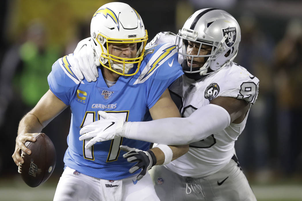 Los Angeles Chargers quarterback Philip Rivers (17) is sacked by Oakland Raiders defensive end ...