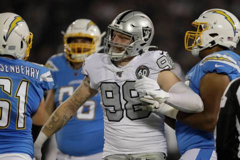 Oakland Raiders defensive end Maxx Crosby (98) reacts next to Los Angeles Chargers center Scott ...