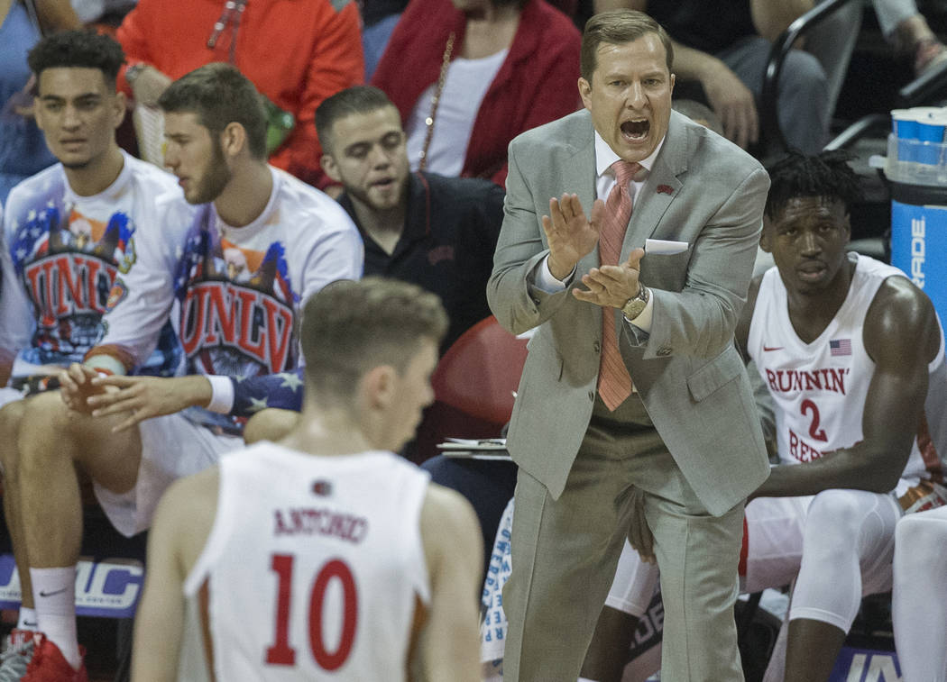 UNLV Rebels head coach T.J. Otzelberger, top/right, directs his team during their NCAA basketba ...