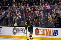 Vegas Golden Knights center Nicolas Roy (10) gives away his stick to a lucky fan after scoring ...
