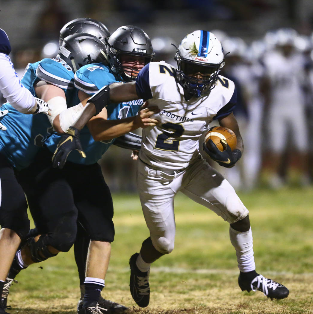 Foothill's Kendric Thomas (2) runs the ball past Silverado's Gregory Hunt (1) during the first ...