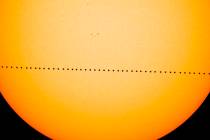 In a composite image provided by NASA, the planet Mercury passes directly between the sun and E ...