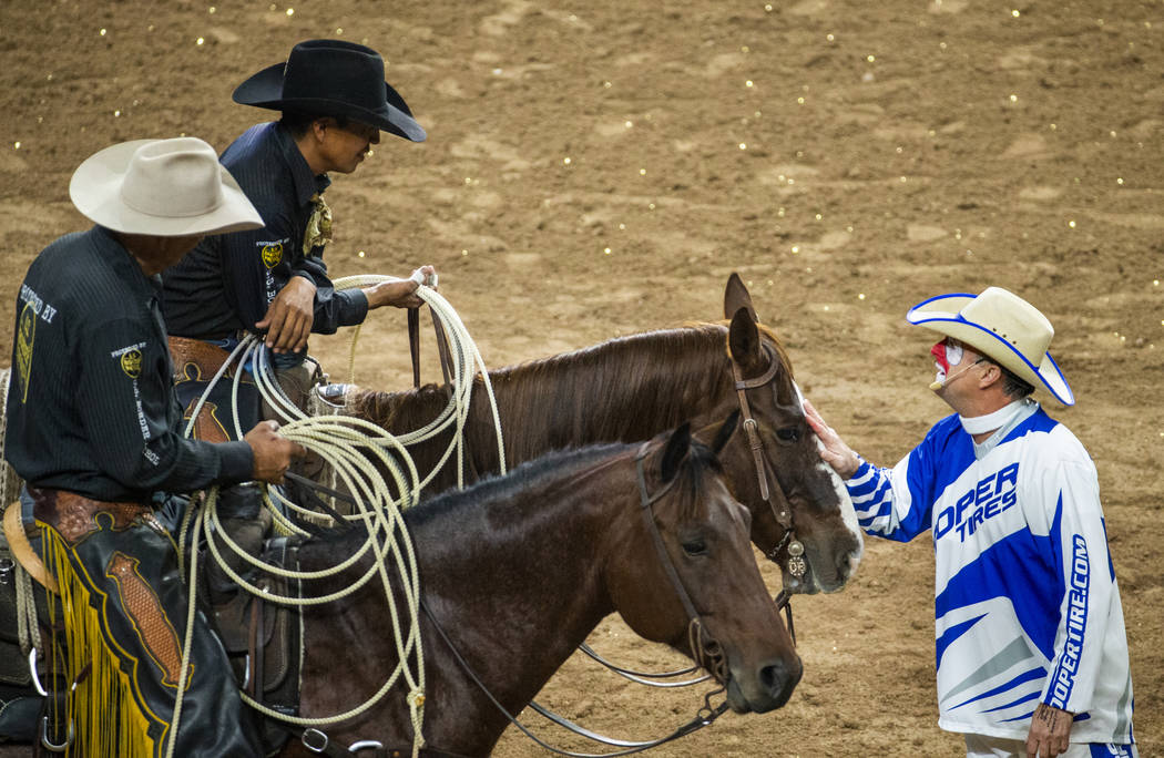 Rodeo clown Flint Rasmussen, right, jokes around with safety man Derrick Begay, top left, durin ...