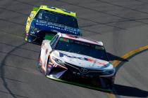 Denny Hamlin (11) drives through Turn 4 in front of Paul Menard during a NASCAR Cup Series auto ...
