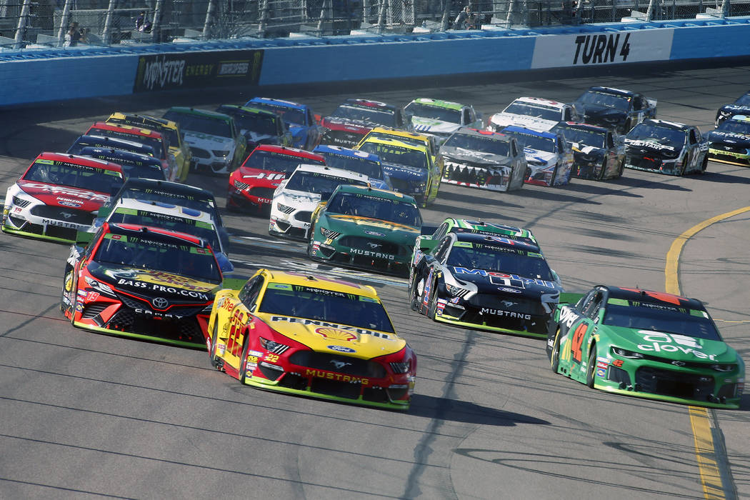 Joey Logano (22) leads the field through Turn 4 during a NASCAR Cup Series auto race at ISM Rac ...