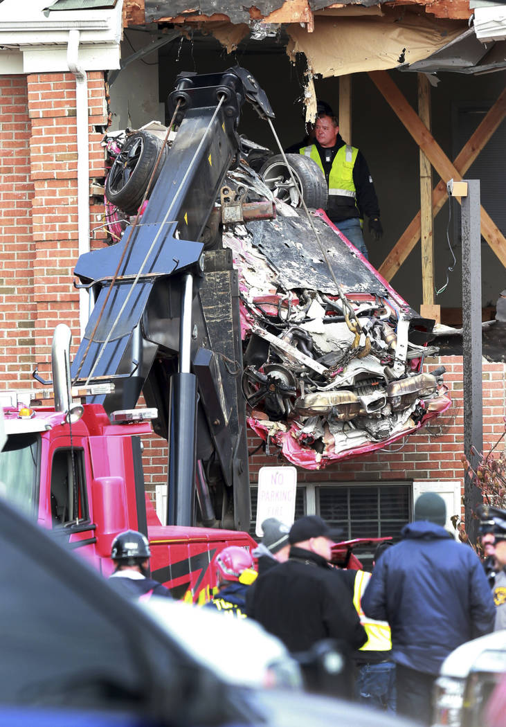 A Porsche is removed form the second story of a building after the convertible went airborne an ...