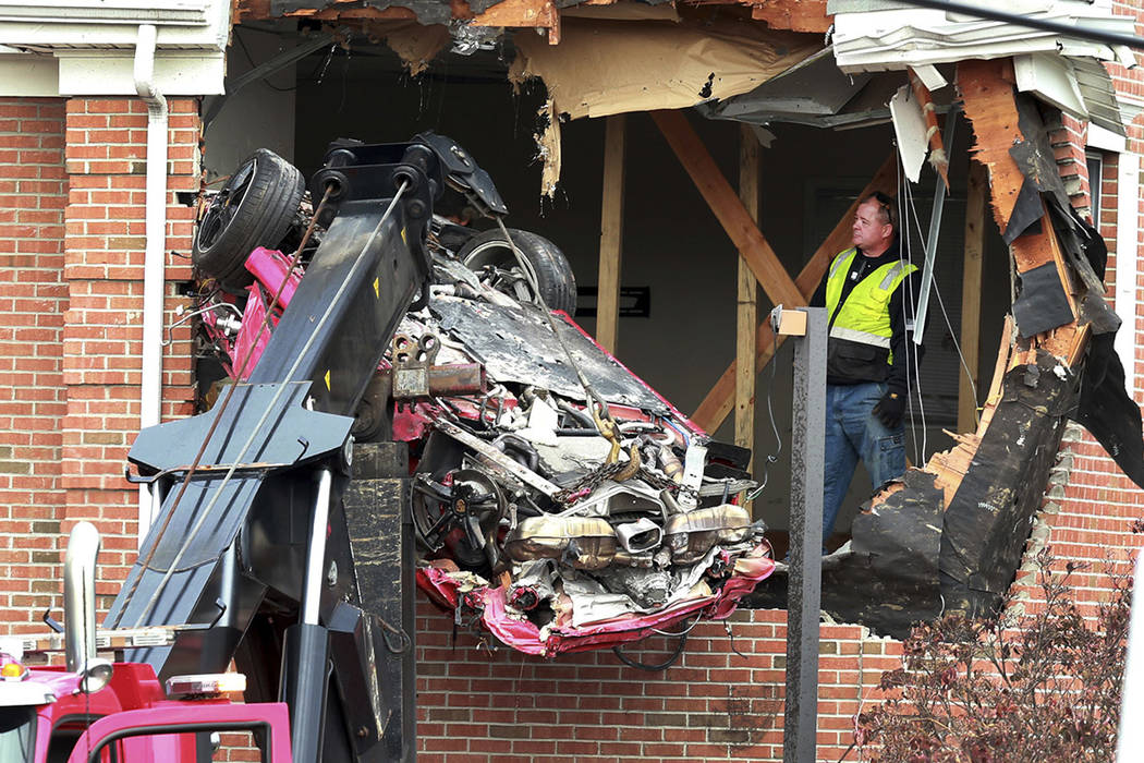A Porsche is removed form the second story of a building after the convertible went airborne an ...