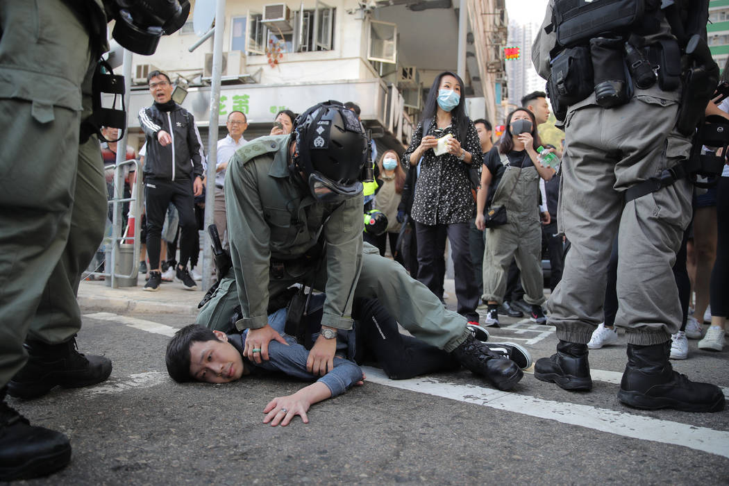 A protester is detained in Hong Kong Monday, Nov. 11, 2019. Hong Kong is in the sixth month of ...