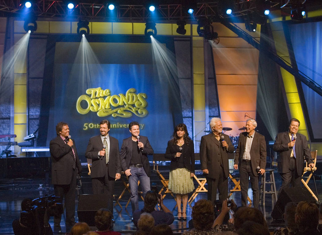 Jimmy, from left, Jay, Donny, Marie, Merrill, Wayne and Alan Osmond stand on stage during a mee ...
