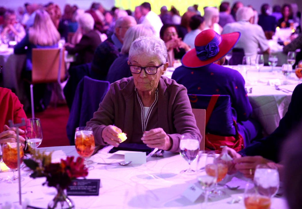 Mary Haupt of Las Vegas lights an electronic candle for a loved one during Death Over Dinner - ...