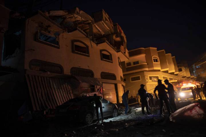 Palestinians check the damage of a house targeted by Israeli missile strikes in Gaza City, Tues ...