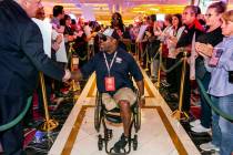 Wounded veteran Charles Armstead, center, is greeted and applauded as he makes his way through ...