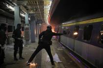 A student hurls a molotov cocktail into a train parked inside the Chinese University MTR statio ...