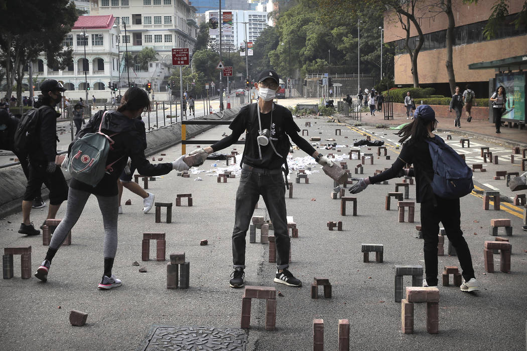 Protestors move bricks as they barricade a road near the Hong Kong Polytechnic University in Ho ...
