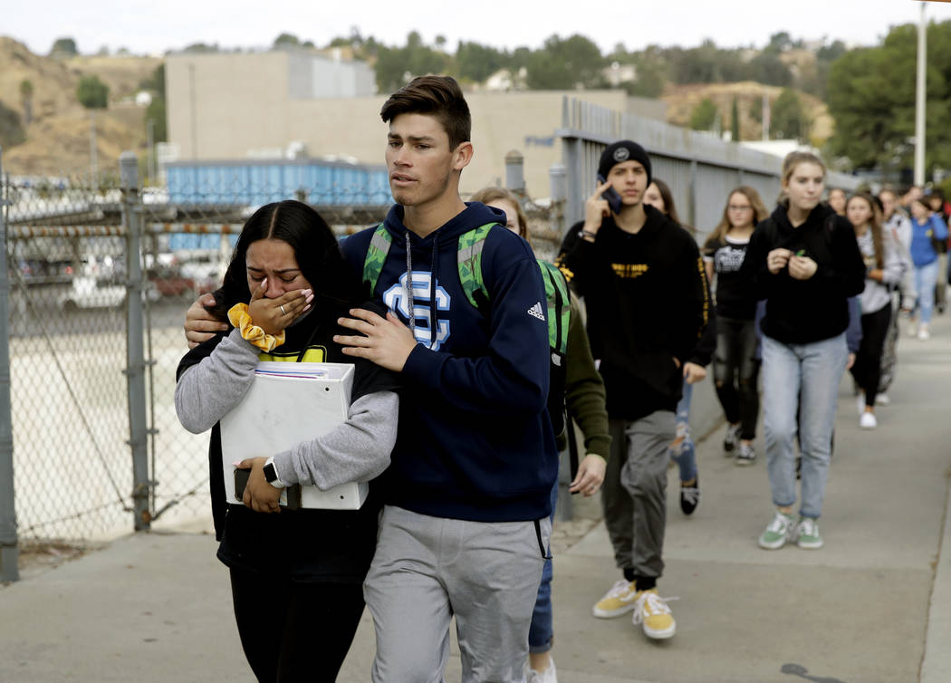 Students are escorted out of Saugus High School after reports of a shooting on Thursday, Nov. 1 ...