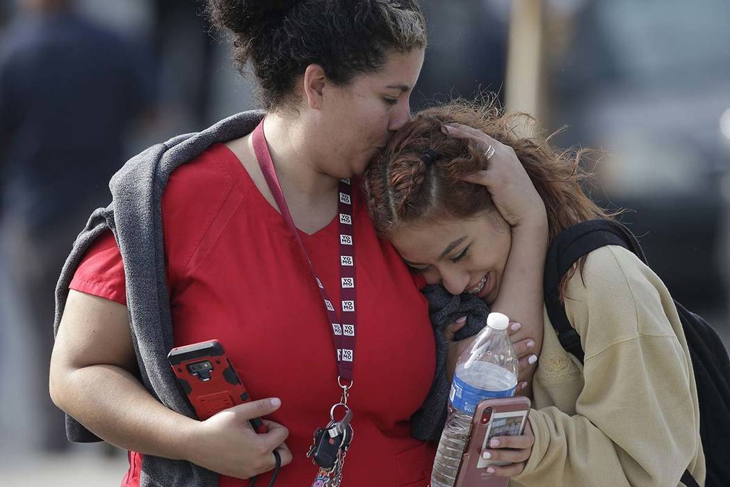 Parent Alicia Leon, left, kisses her daughter, Alejandra Cruz, a tenth grader, as they reunite ...