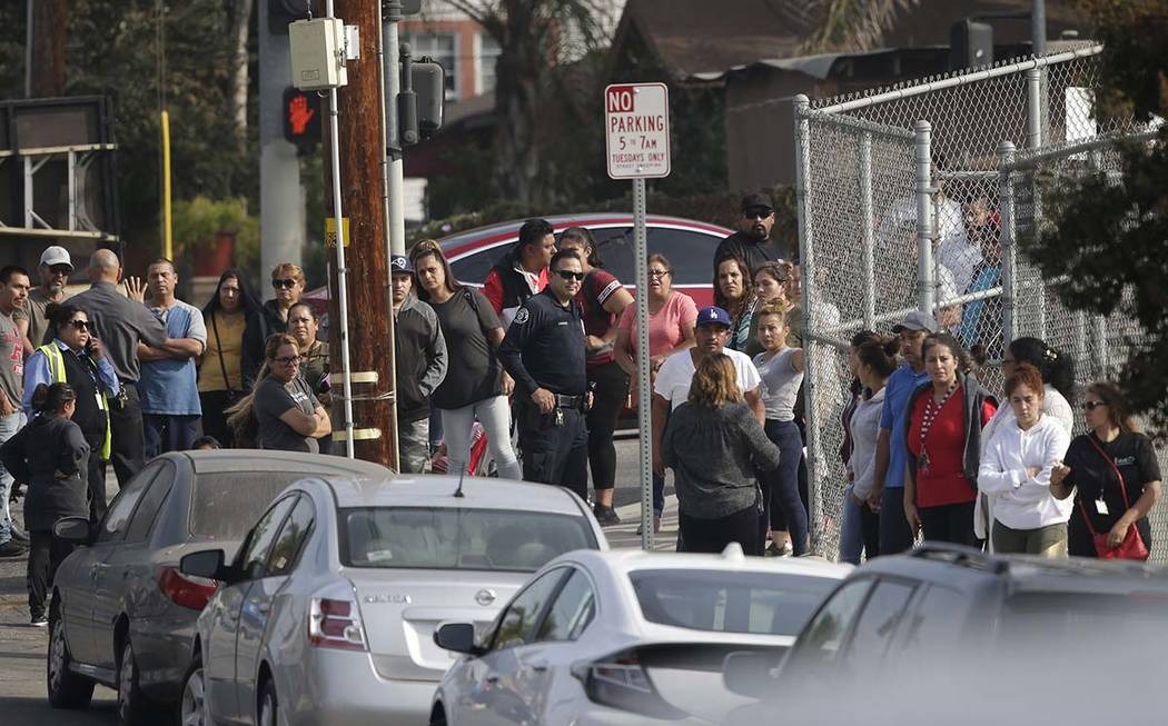 Parents wait to be reunited with students at the Esteban Torres High School in unincorporated E ...