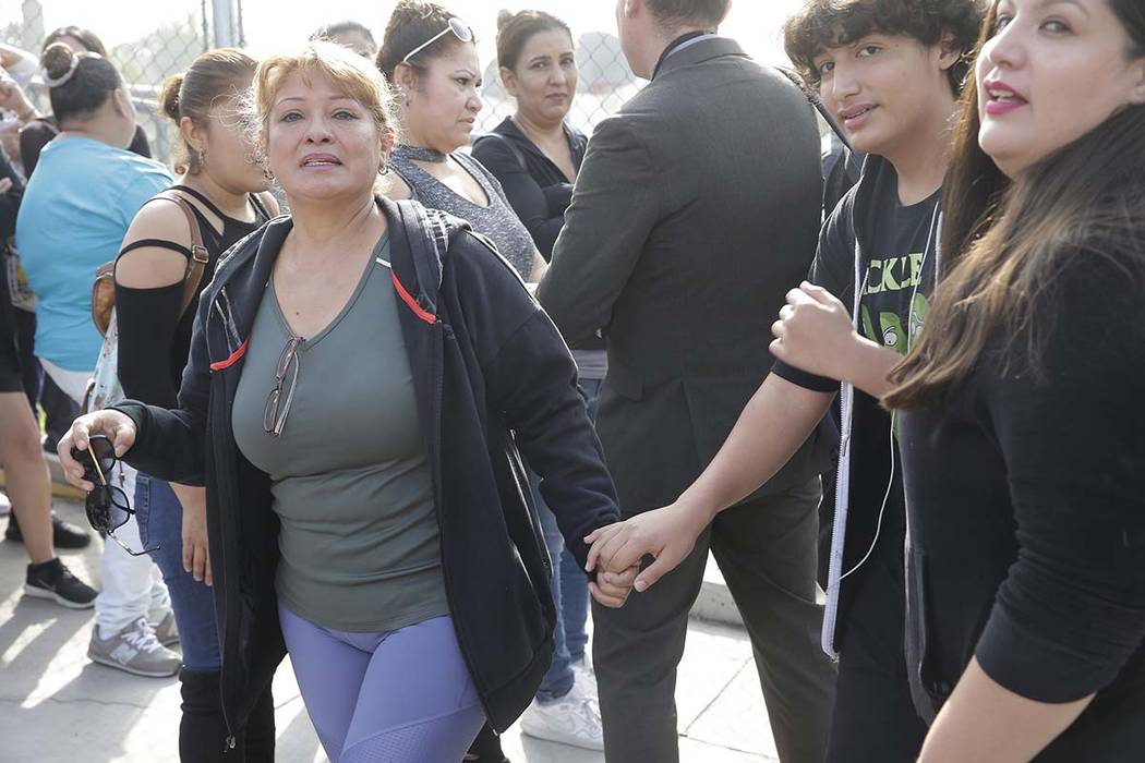 Unidentified parents are reunited with their children, after a school lock down at the Esteban ...