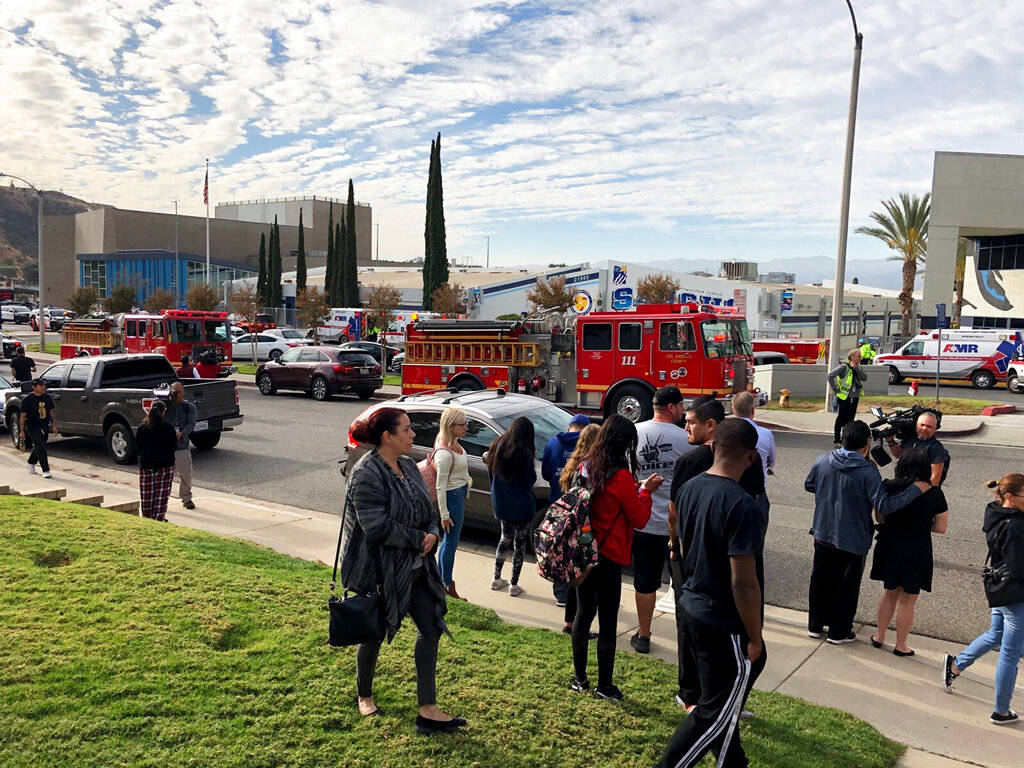 People wait for students and updates outside of Saugus High School after reports of a shooting ...