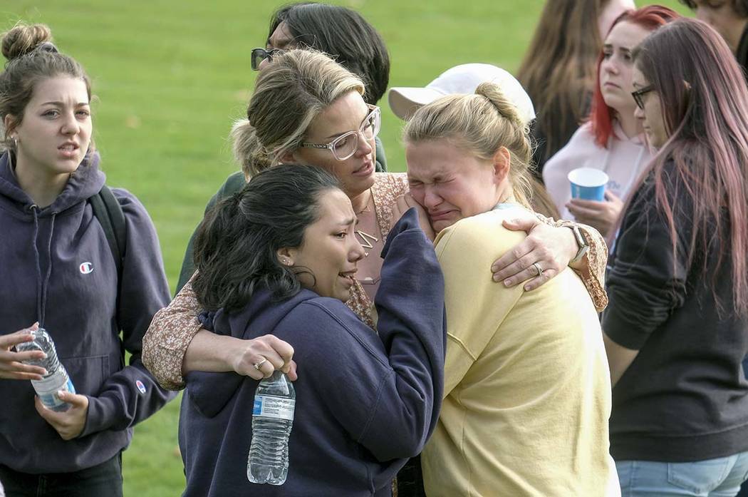 Students are comforted as they wait to be reunited with their parents following a shooting at S ...