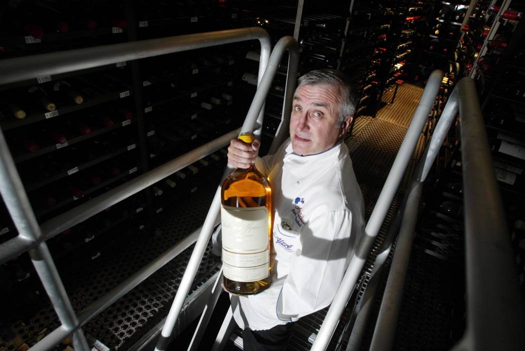 Longtime Las Vegas restaurateur Andre Rochat displays a bottle from inside the wine cellar of h ...