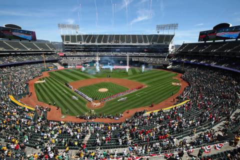 The Los Angeles Angels and the Oakland Athletics stand for the national anthem at Oakland Colis ...