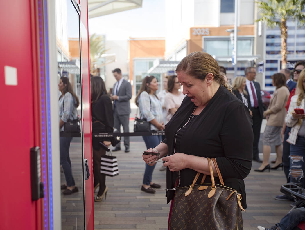 Susan Summers uses the Giving Machine, a vending machine that offers different items from chari ...