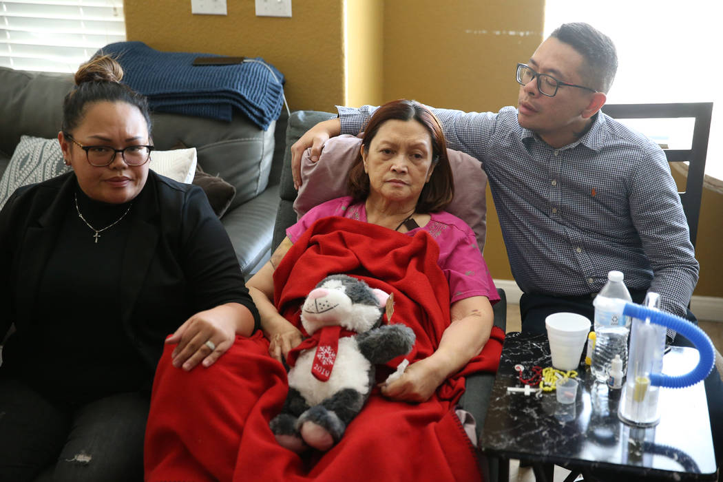 Nimfa Escobia, center, with her children, Misha, left, and Nimar Escobia, talk at their home in ...