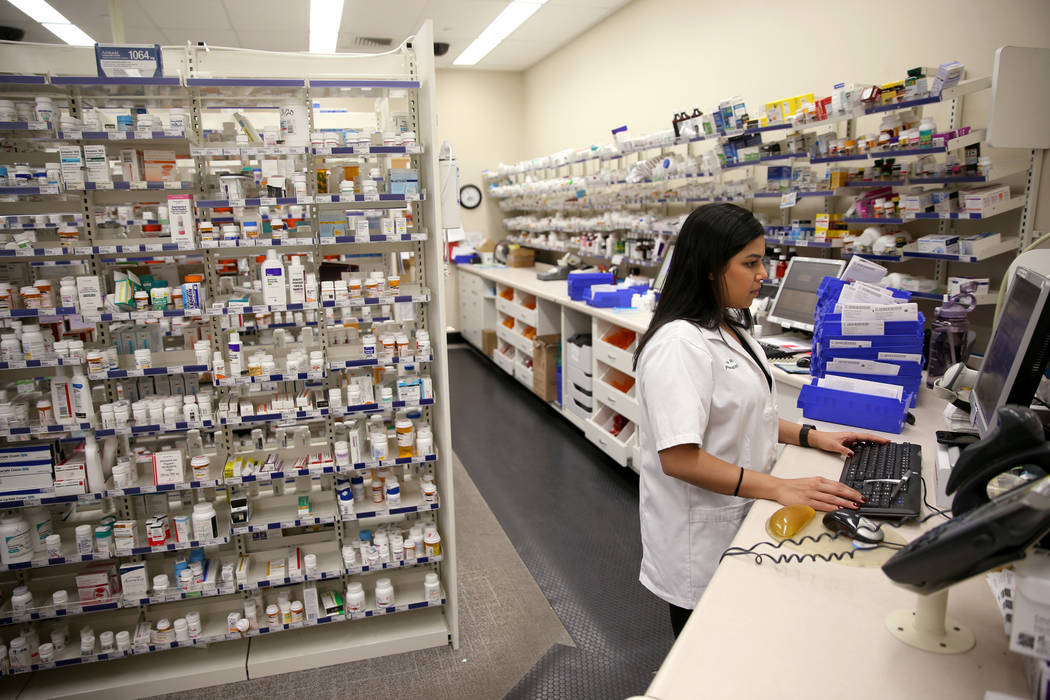 Pharmacy Manager Maria Masood fills a customer's prescription at the Walgreens pharmacy on Blue ...