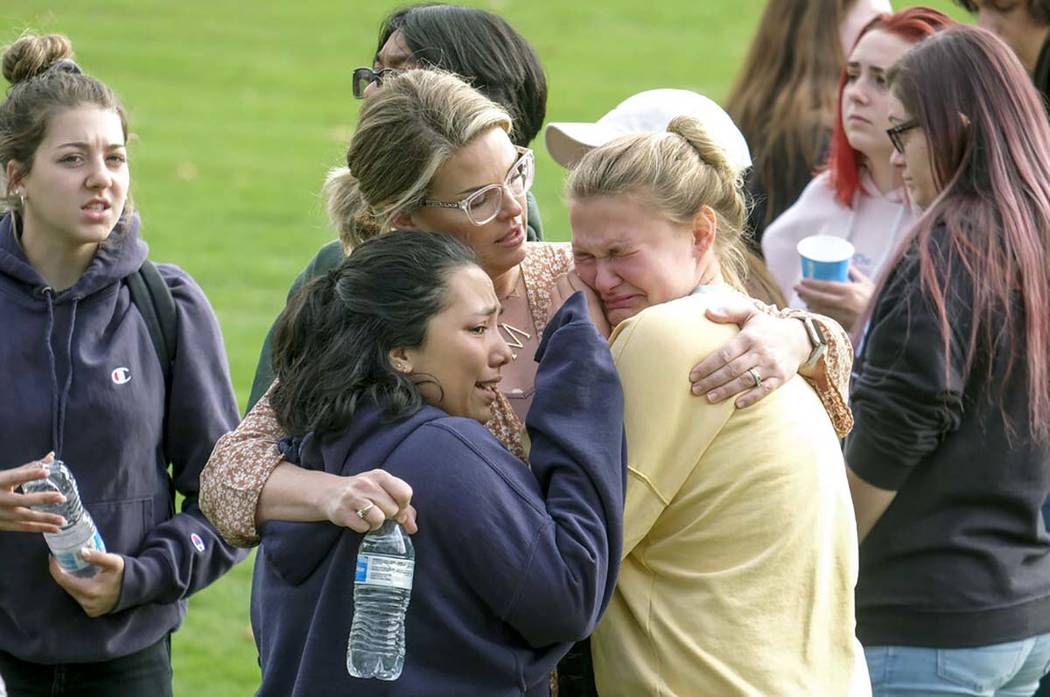 Students are comforted as they wait to be reunited with their parents following a shooting at S ...