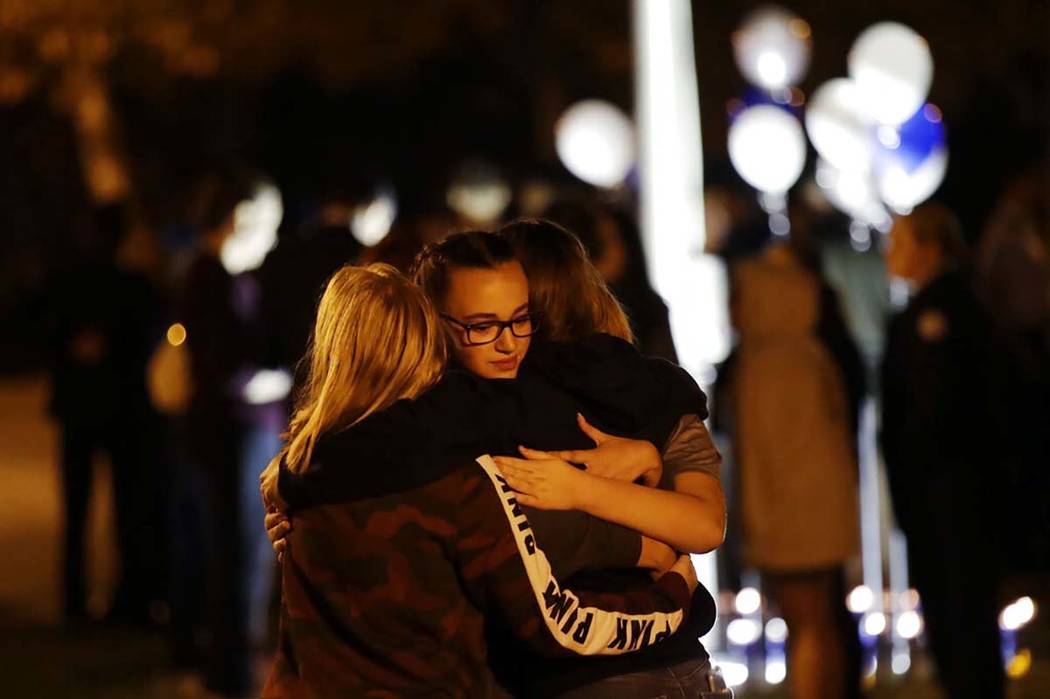 Students embrace during a vigil at Central Park in the aftermath of a shooting at Saugus High S ...