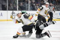 Los Angeles Kings right wing Adrian Kempe, back, falls onto Vegas Golden Knights center William ...