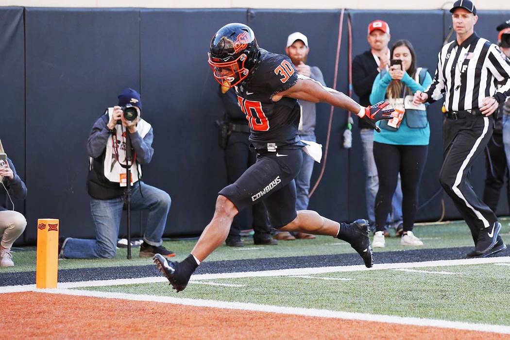Oklahoma State running back Chuba Hubbard (30) leaps into the end zone with a touchdown in the ...