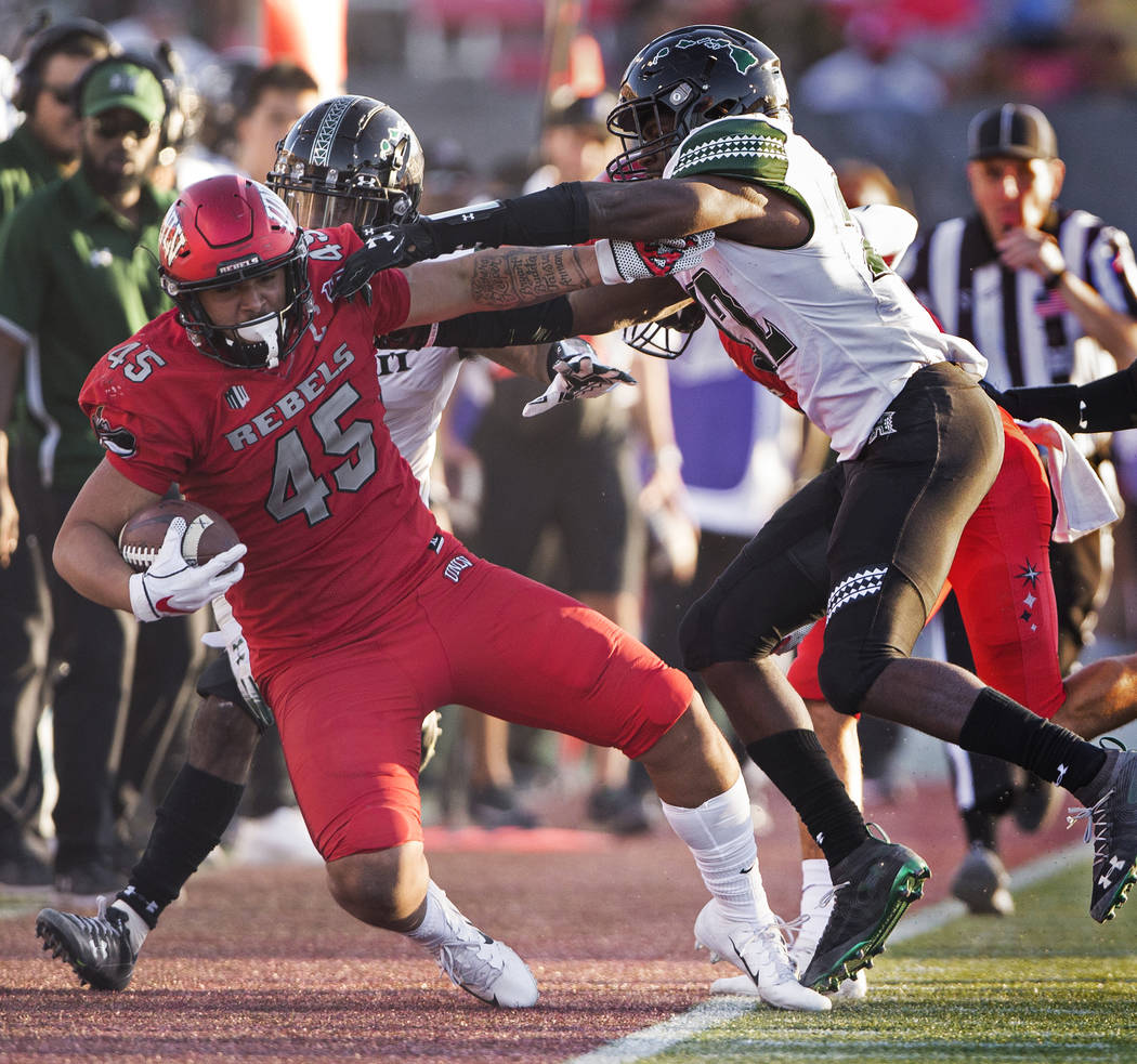 UNLV Rebels tight end Giovanni Fauolo Sr. (45) is knocked out of bounds by Hawaii Warriors defe ...