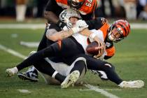 Cincinnati Bengals quarterback Ryan Finley, front, is sacked by Oakland Raiders defensive end M ...