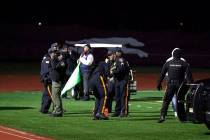 Police investigate the scene after a gunman shot into a crowd of people during a football game ...