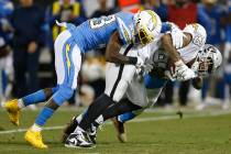 Oakland Raiders tight end Darren Waller, right, is tackled by Los Angeles Chargers cornerback M ...