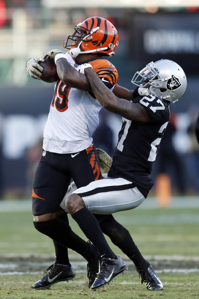 Cincinnati Bengals wide receiver Auden Tate is stopped with the ball by Oakland Raiders cornerb ...