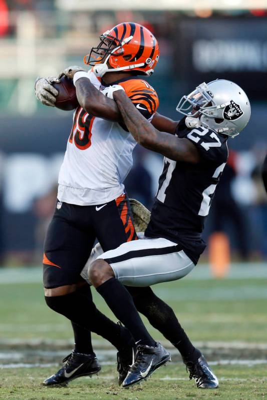 Cincinnati Bengals wide receiver Auden Tate is stopped with the ball by Oakland Raiders cornerb ...