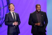 With their eyes closed for prayer, Joel Osteen, left, and Kanye West laugh as West makes a joke ...