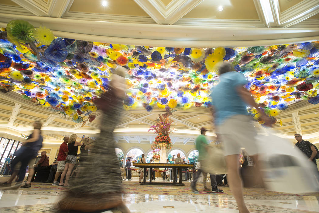 Patrons pass by the Chihuly Fiori de Como glass sculpture in the lobby of Bellagio in Las Vegas ...