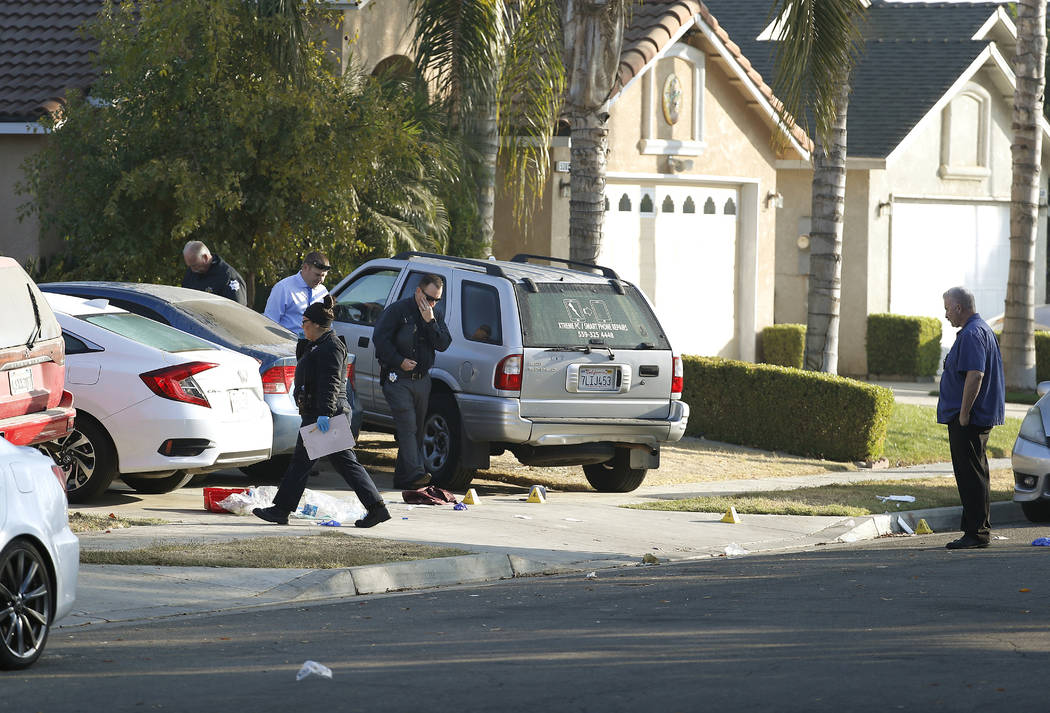 Fresno police investigators work the driveway where a shooting took place at a house party whic ...