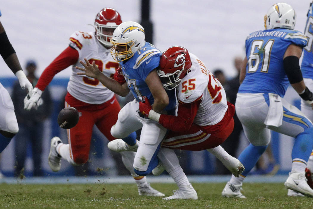 Los Angeles Chargers quarterback Philip Rivers, center, is sacked by Kansas City Chiefs defensi ...