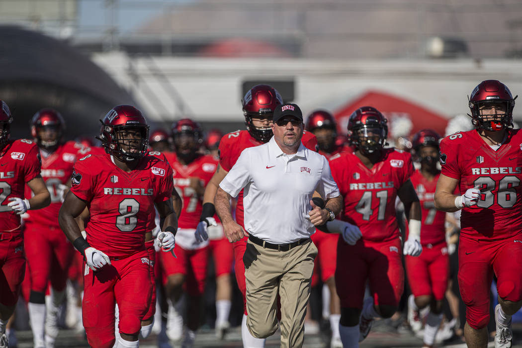 UNLV Rebels head coach Tony Sanchez leads his team on to the field before the start of their NC ...