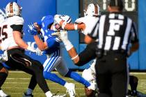 BYU wide receiver Talon Shumway (21) gets his head wrenched by Idaho State defensive back Manas ...