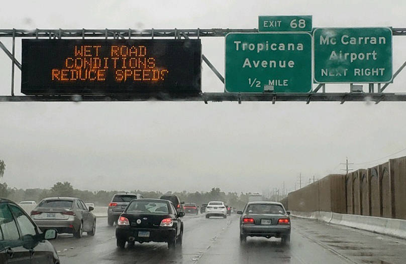 A sign warns motorists of wet road conditions on US 95 near Tropicana, Wednesday, Nov. 20, 2019 ...