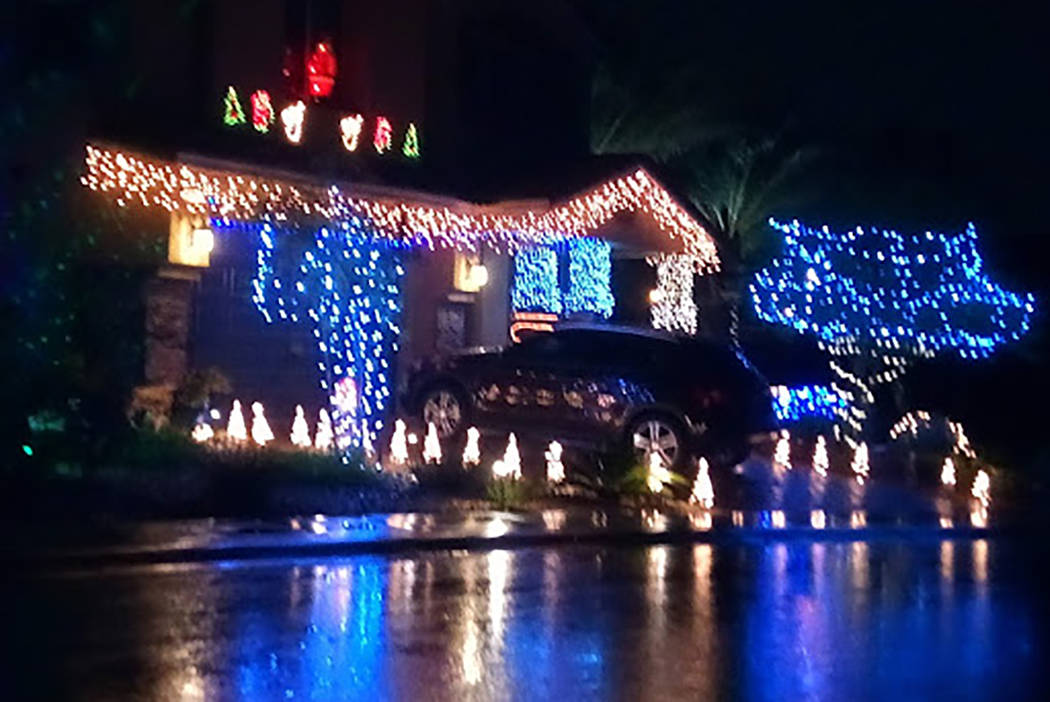Water from early Wednesday, Nov. 20, 2019, rainfall reflects the Christmas lights at a home on ...