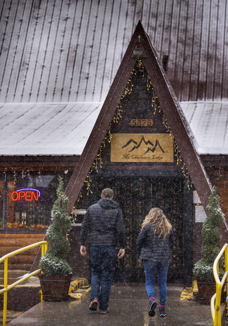 A couple walks through snow outside Mt. Charleston Lodge on Wednesday, Nov. 20, 2019. (L.E. Bas ...