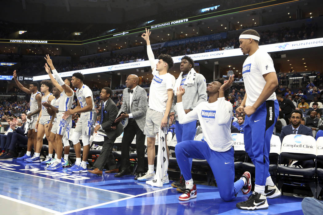 Memphis' James Wiseman (second from right) goes down on his knees as he and his teammates celeb ...